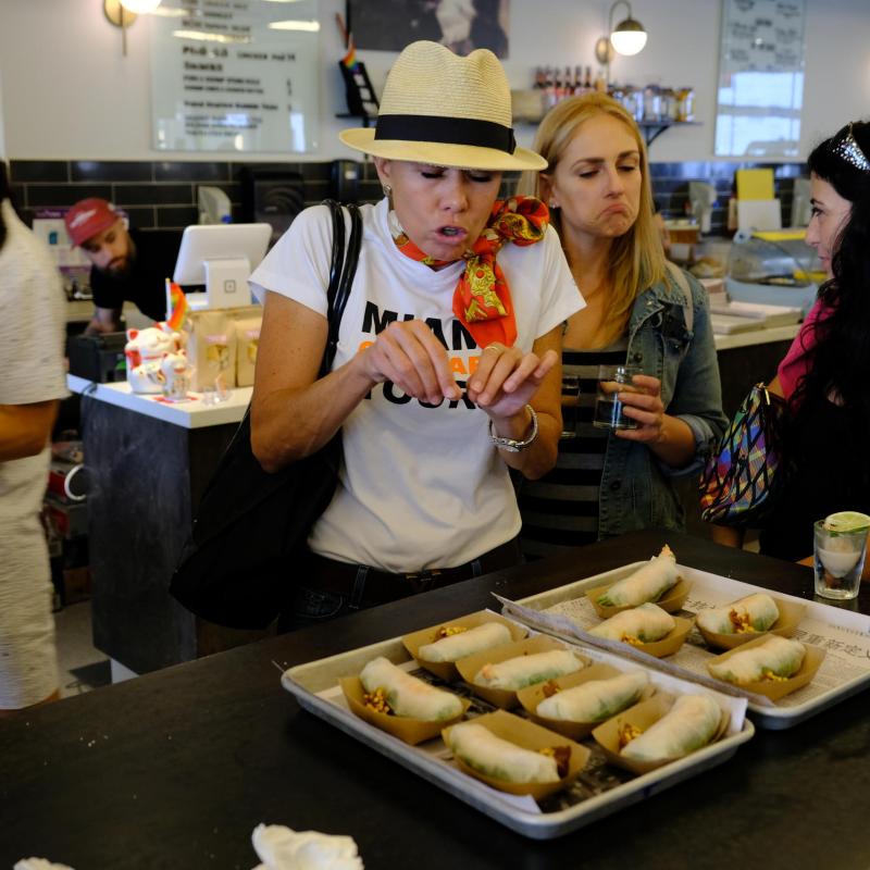 a group of people standing around a table with food
