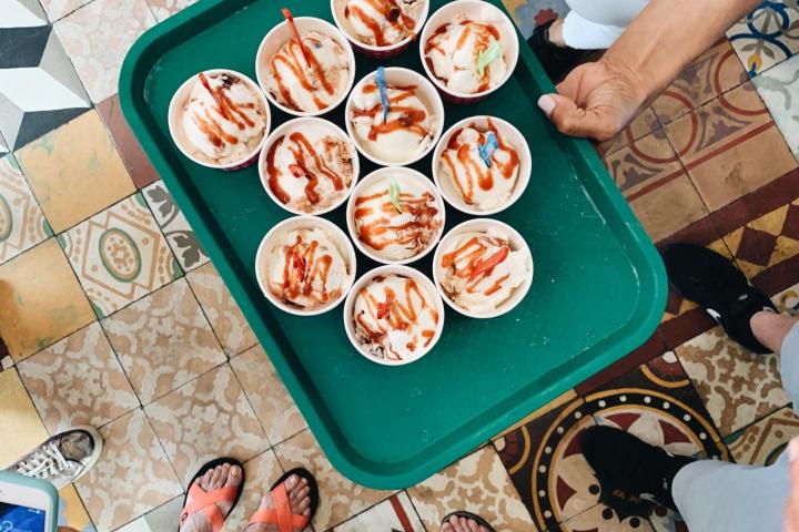 a group of people sitting at a table with food